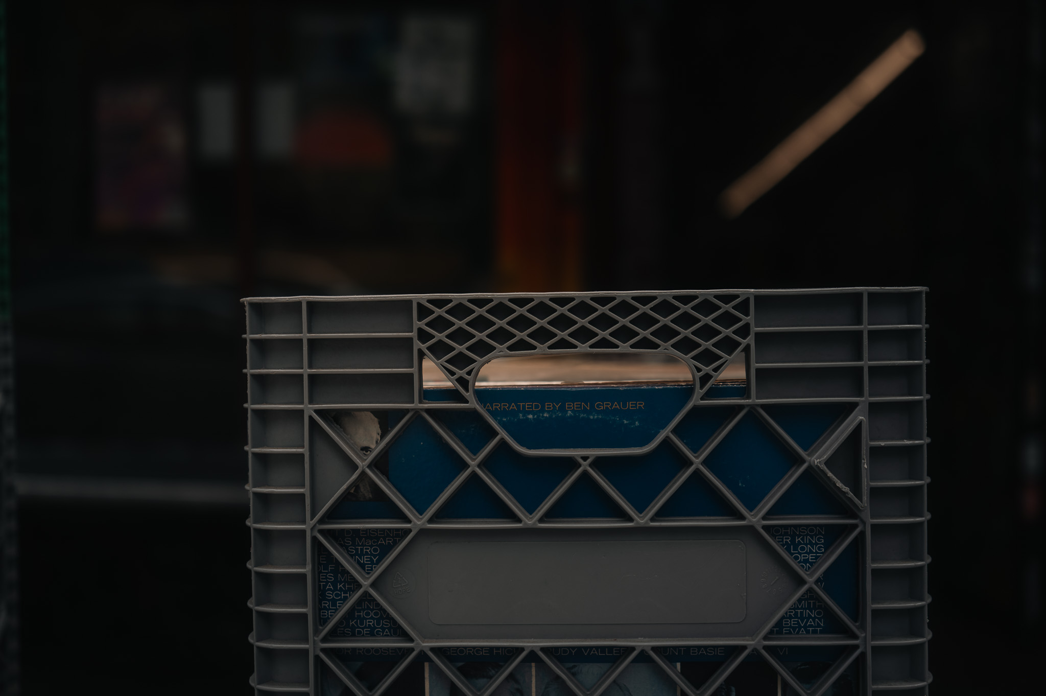 Macro of a single crate of records, the words 'NARRATED BY BEN GRAUER' visible through the grid.