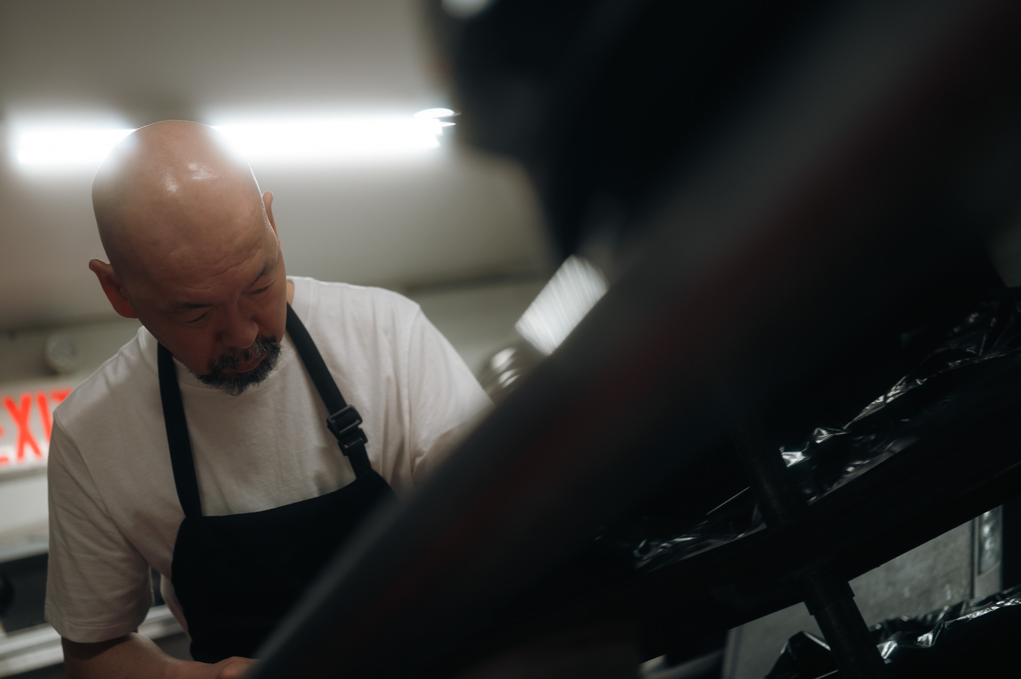 A chef in apron working the line, B&W with a tilted frame.